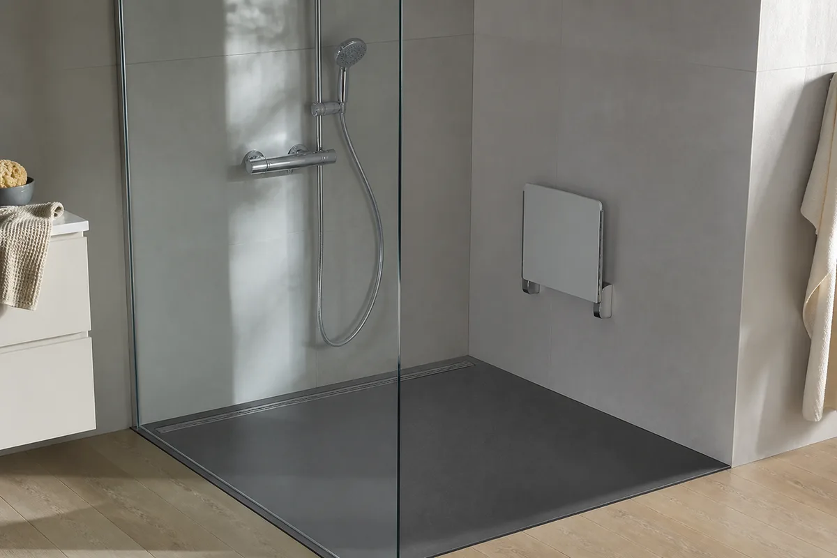 Douche de plain-pied carrelée avec siège rabattable et barre d&rsquo;appui, lumière douce du matin