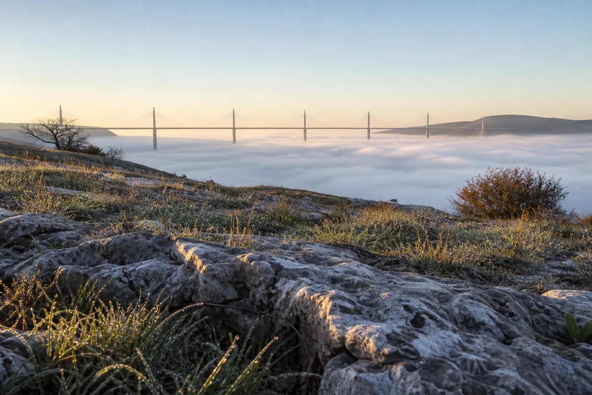 Le viaduc de Millau émergeant d&rsquo;une mer de nuages au lever du jour